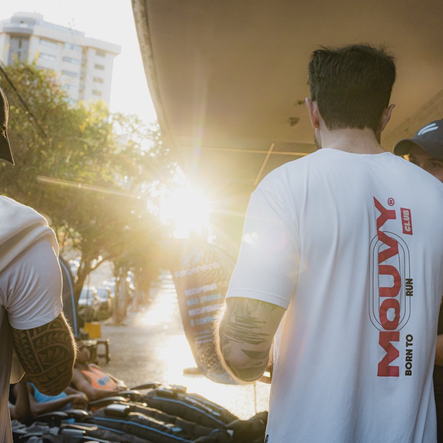 Crew do Mouvy Club reunida na rua no fim de tarde, camiseta Mouvy Club Born to Run em primeiro plano